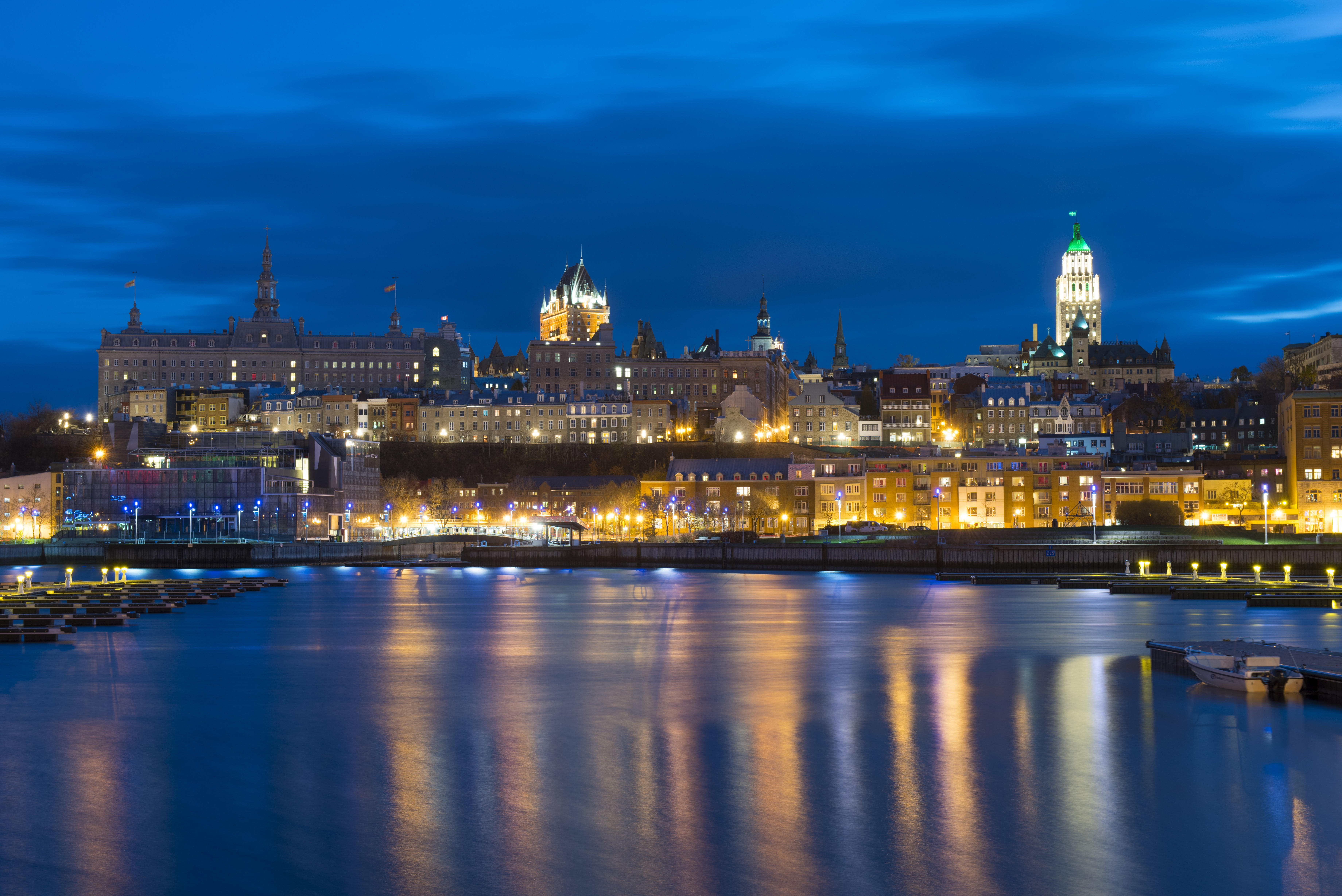 Photographie présentant un ensemble de bâtiments en soirée, alors que leurs lumières se reflètent à la surface de l’eau. Outre la qualité de son héritage architectural, Québec figure sur la liste du patrimoine mondial de l’UNESCO pour son apport culturel et historique. Ses origines remontent aux 16e et 17e siècles, à l’époque de la Nouvelle-France. La ville a su au fil du temps se moderniser, tout en conservant son héritage linguistique et culturel exceptionnel. Québec est considérée comme le berceau historique de l’Amérique francophone.